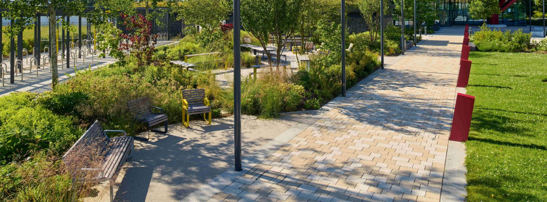 Modal X paving laid on a pathway next to wooden furniture and lots of greenery