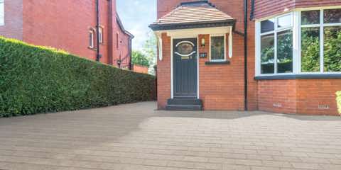 Marshalls Lunar paving in rosa laid on a driveway in front of a red brick house