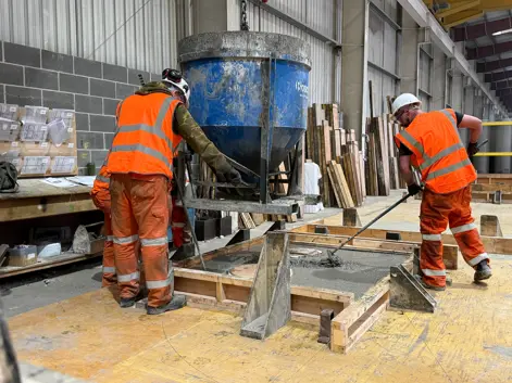Marshalls staff working on precast products in a factory wearing orange hi-vis